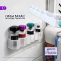 A white refrigerator-mounted hexagon vial holder shown holding several small medicine-style vials, with a matching holder floating above and text reading 'FRIDGE MOUNT HEXAGON VIAL HOLDER.' The scene is a real fridge environment with other objects partially visible, so this is Lifestyle rather than Product/Packaging.