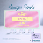 A product mockup showing three small clear vials beneath a pink rectangular label with a yellow hexagon graphic and the text 'Hexagon Simple', '10 MG', and 'For Research Use Only'. The PeptiPrints logo appears in the lower right corner.
